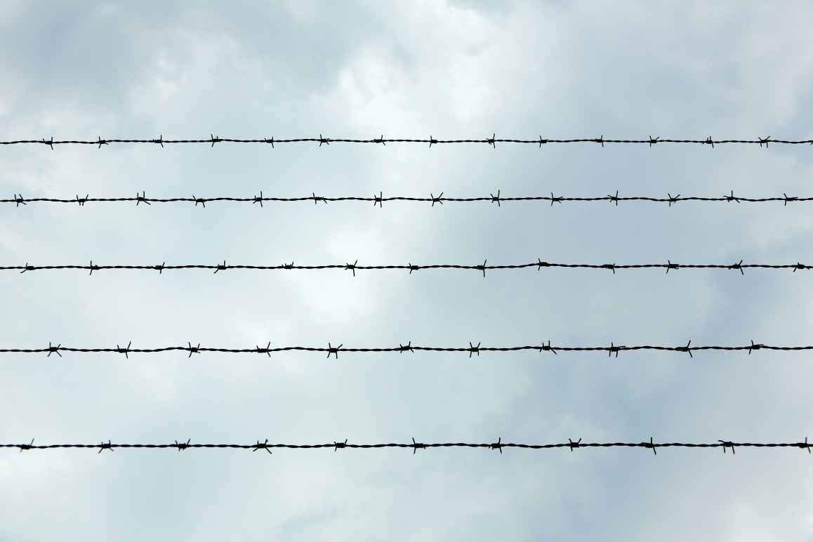 Barbed wire in front of blue sky