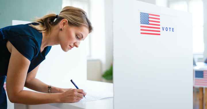 Woman filling out a ballot at a voting booth