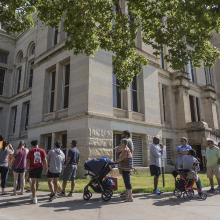 A long line of voters wraps around the Sedgwick County Historic Courthouse in Wichita, Kan., on the last day of early voting on Aug. 1, 2022. Kansas' top elections official warned voters Monday, Oct. 31, 2022, that text messages they were receiving could 
