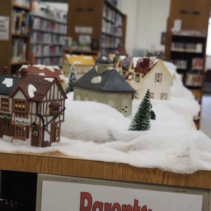zoomed in photo on christmas display of a miniature village with quaint buildings and snow